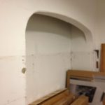 The picture window opening covered in drywall